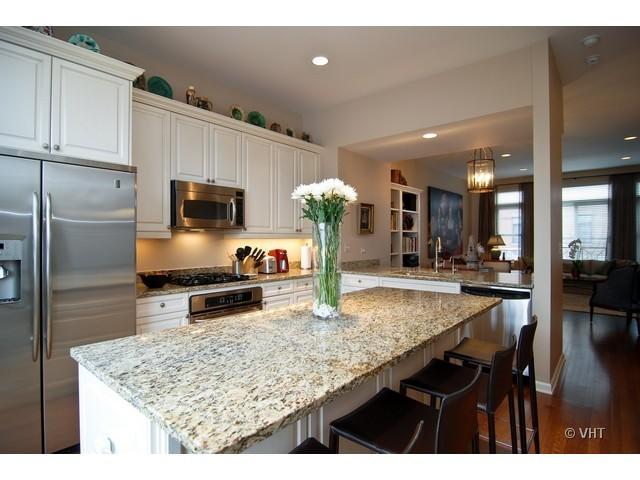 732 West 15th Street Chicago, IL 60607 - Photo 3 of 12 a kitchen with kitchen island granite countertop wooden cabinets and a refrigerator