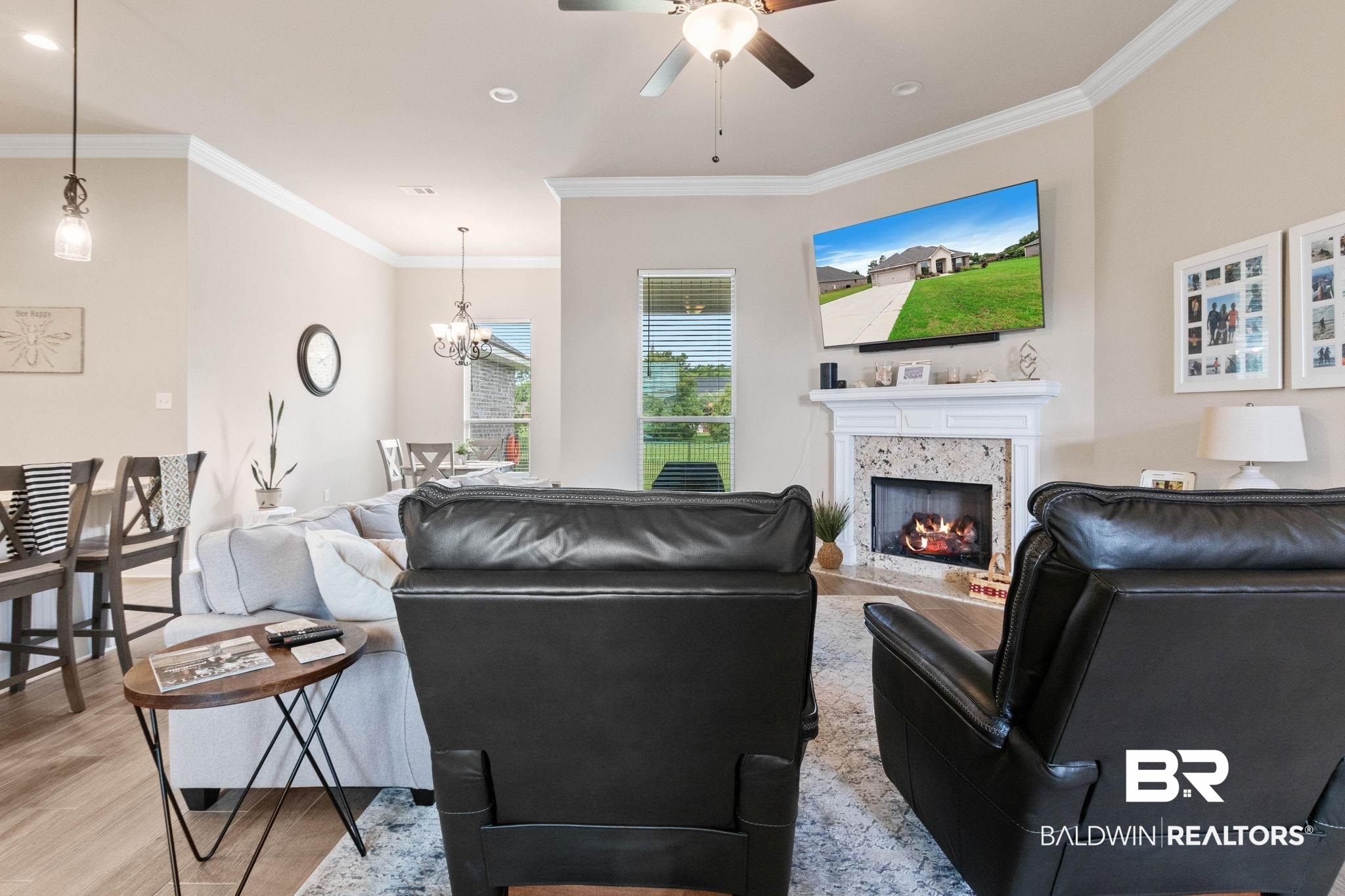 22244 Hibiscus Circle Foley, AL 36535 - Photo 19 of 51 Living area featuring a stone-surround fireplace with a white mantel, crown molding, a ceiling fan, and wood-finish flooring