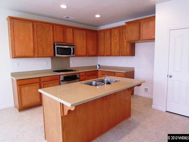 11410 Cervino Drive Reno, NV 89521 - Photo 2 of 13 a kitchen with a sink a stove and a microwave