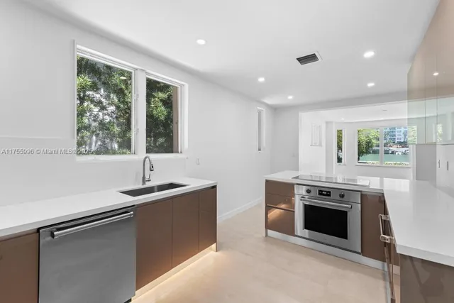 a kitchen with stainless steel appliances granite countertop a stove and a sink