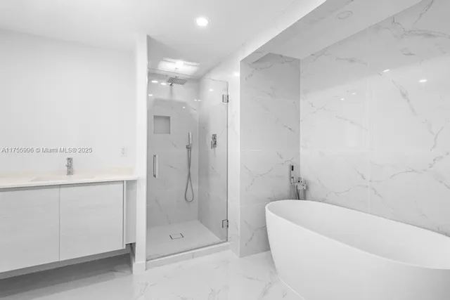 a bathroom with a tub shower sink and mirror