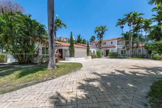a front view of a house with a yard and potted plants