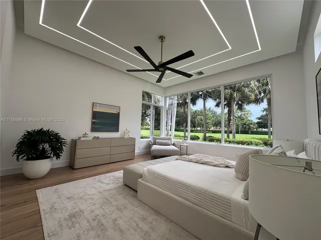 a living room with furniture ceiling fan and a large window