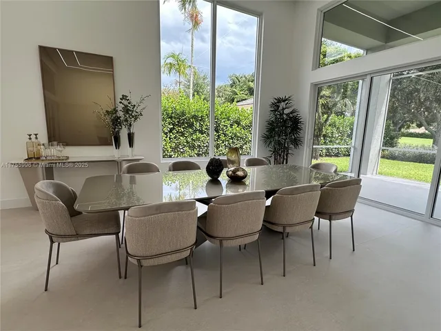 a dining room with furniture and a large window