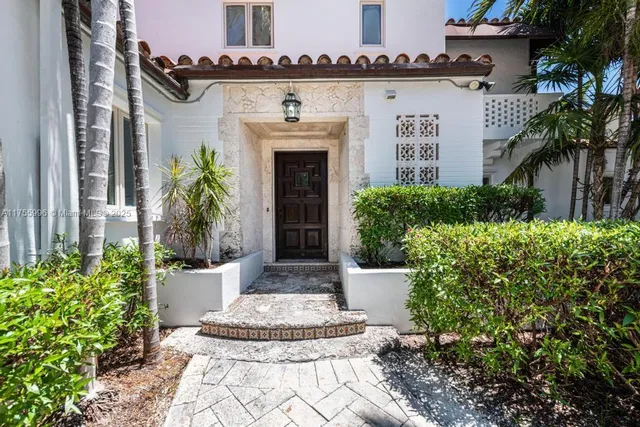a front view of a house with plants