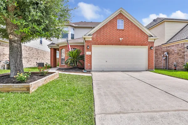 a front view of a house with a yard and potted plants