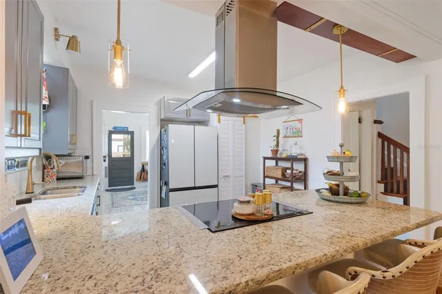 a kitchen with stainless steel appliances granite countertop a sink and a refrigerator
