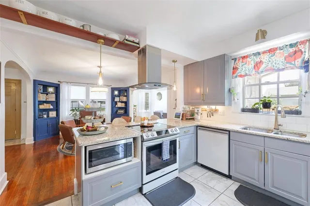 a kitchen with a stove sink and cabinets