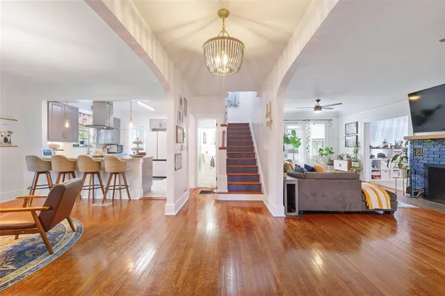 a view of a dining room kitchen with furniture a chandelier and wooden floor