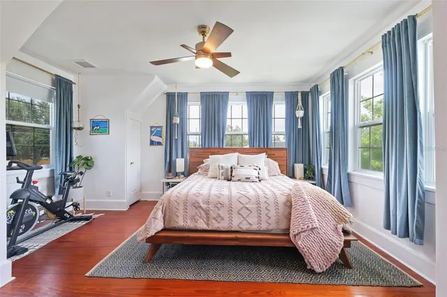 a bedroom with a bed and wooden floor