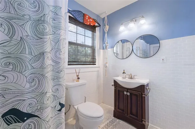 a bathroom with a toilet a sink and mirror