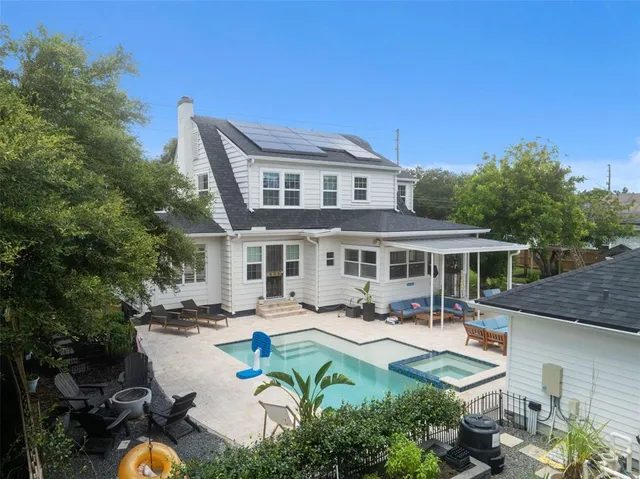 a view of a patio with couches chairs potted plants and large tree