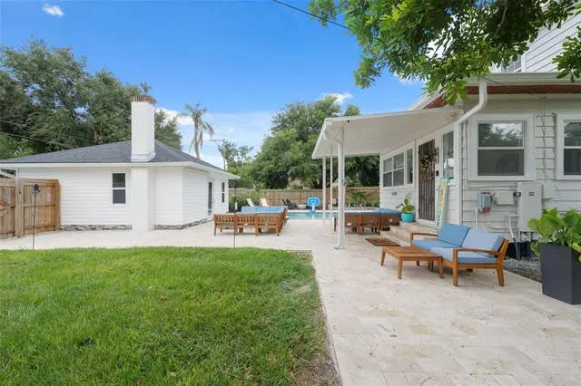 a view of a house with backyard sitting area and garden