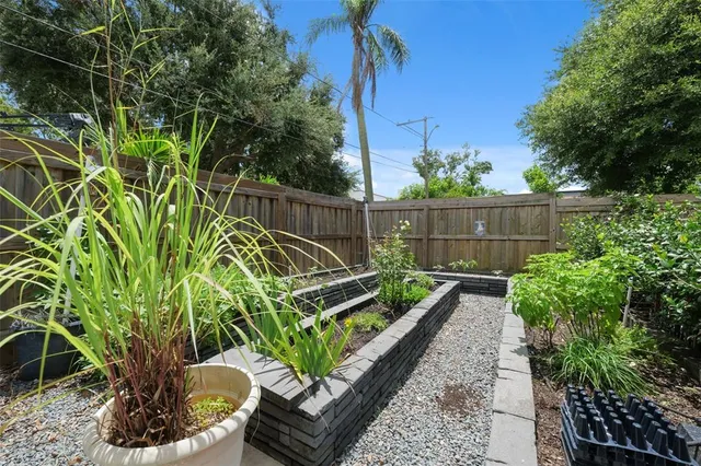 a view of a backyard with plants and a bench