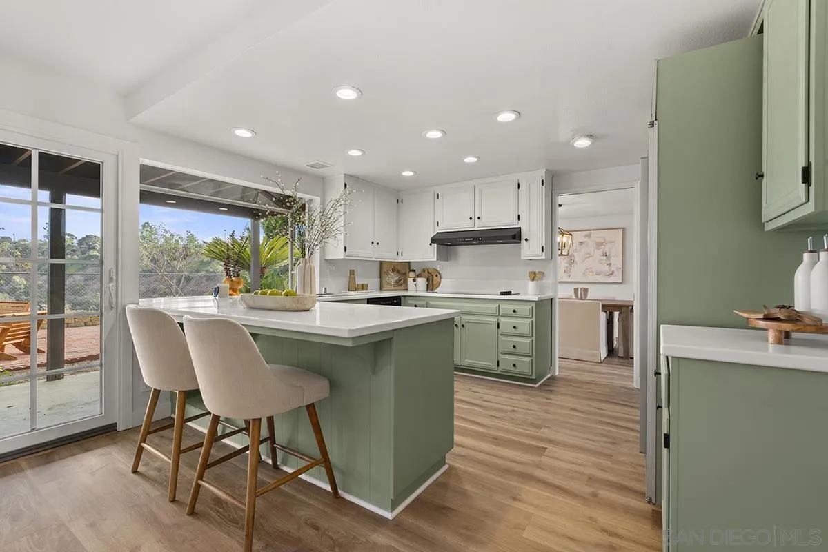 a kitchen with a table chairs refrigerator and cabinets