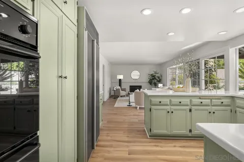 a kitchen with cabinets appliances and a wooden floor