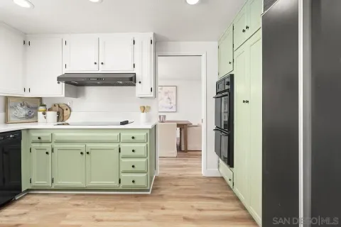 a kitchen with a sink window and cabinets