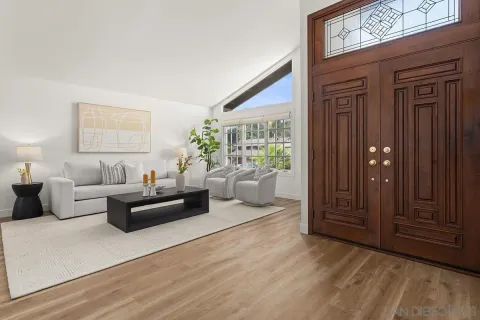 a living room with furniture windows and entryway