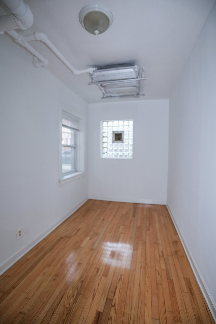 2453 West Gunnison Street, Unit G Chicago, IL 60625 - Photo 8 of 9 a view of an empty room with wooden floor and a window