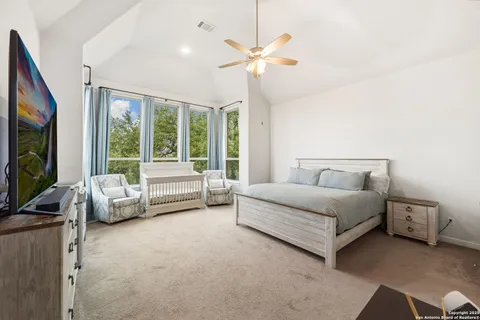 a spacious bedroom with a bed and a flat screen tv