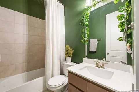 a bathroom with a sink a toilet a shower and a mirror