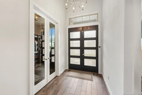a view of a hallway with wooden floor and windows