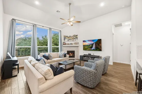 a living room with furniture a large window and a fireplace