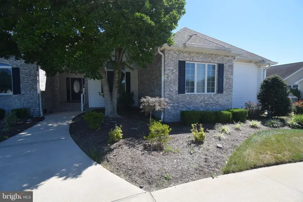 a front view of a house with a yard and a garden