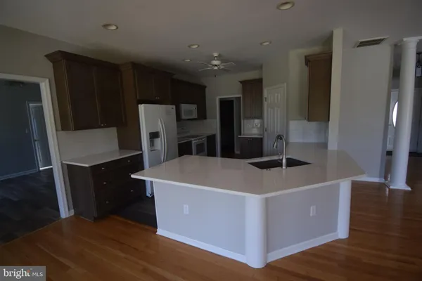 a large kitchen with stainless steel appliances a refrigerator and a stove top oven