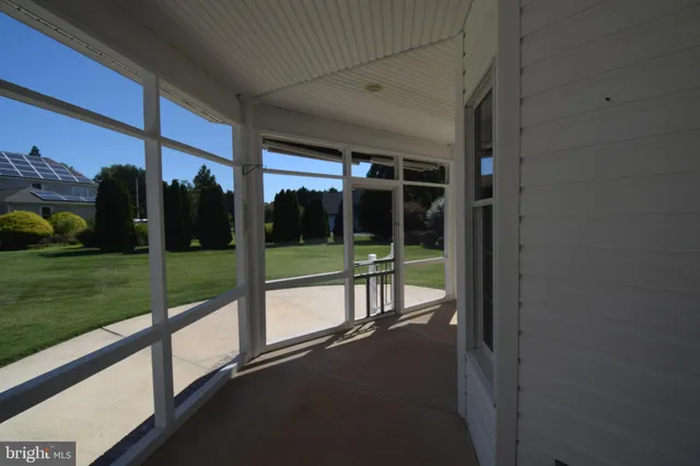 a view of a porch with a floor to ceiling window next to a yard