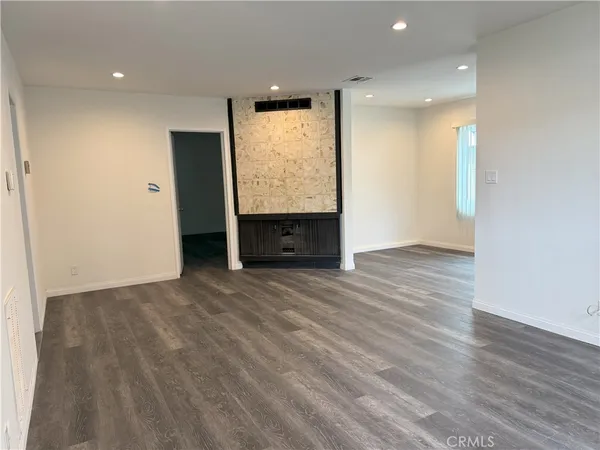 an empty room with wooden floor and window