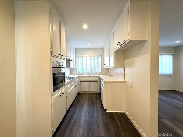 a kitchen with a refrigerator a sink and wooden floor