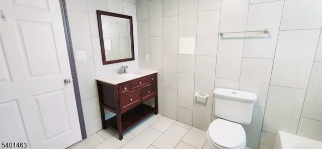 a bathroom with a toilet sink vanity and mirror