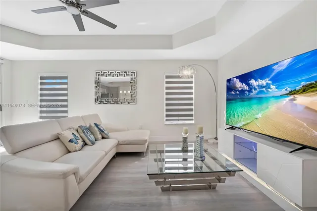 a view of backyard with table and chairs potted plants and large tree