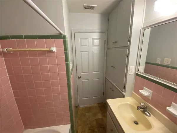 a bathroom with a sink and mirror with shower