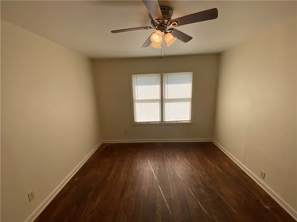 an empty room with a window and a fan