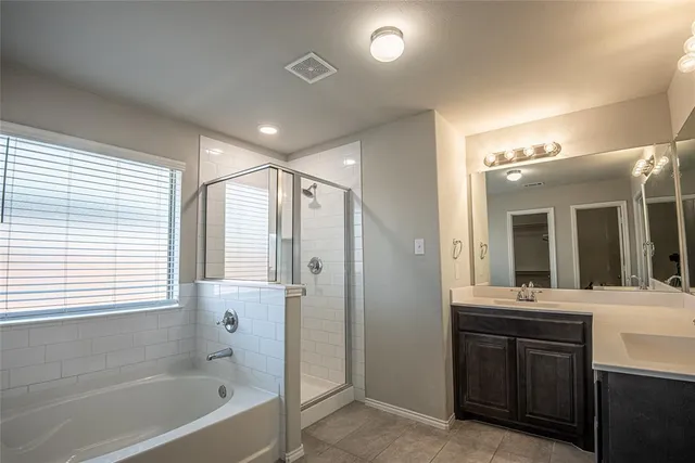 a bathroom with a bathtub a shower a sink and a mirror