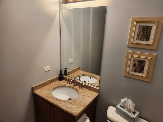a bathroom with a granite countertop sink and a mirror