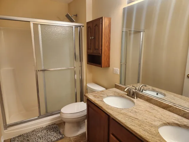 a bathroom with a granite countertop sink toilet and shower