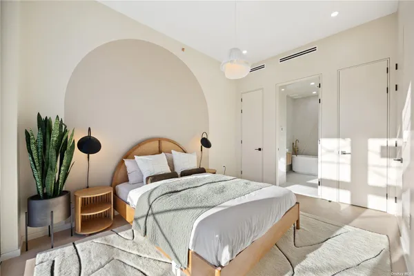 a bedroom with a bed and a potted plant