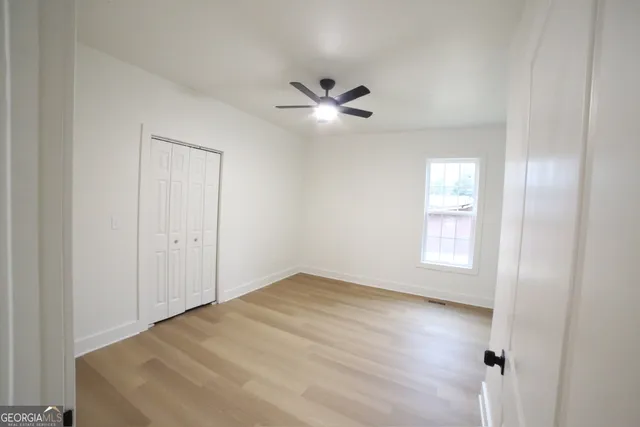 a view of empty room with wooden floor