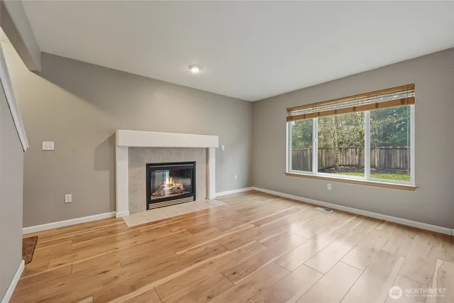 a view of an empty room with a window and a fireplace
