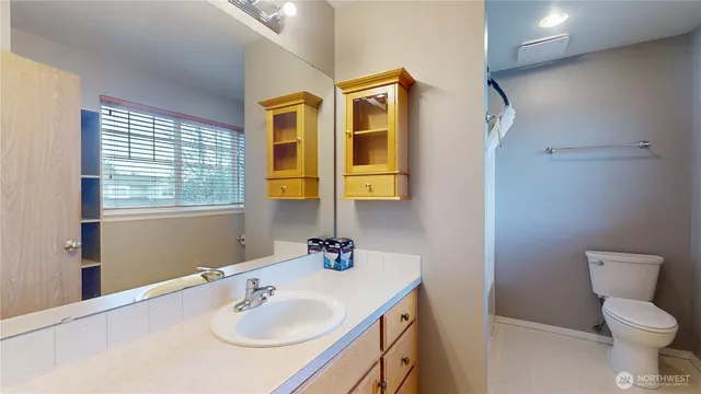 a bathroom with a sink toilet and mirror