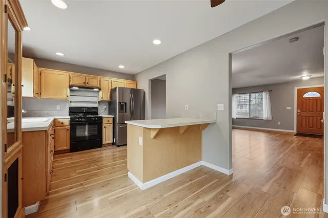 a kitchen with stainless steel appliances granite countertop a refrigerator and a stove top oven