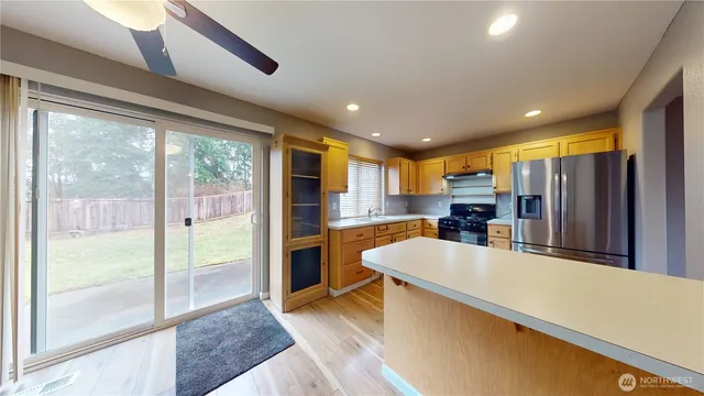 a large kitchen with stainless steel appliances a large window in it