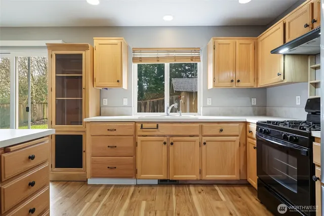 a kitchen with granite countertop a stove a sink and a cabinets