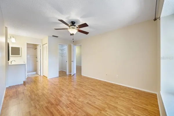 a view of a big room with wooden floor and a ceiling fan