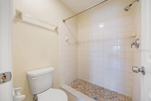 a white toilet sitting next to a bath tub