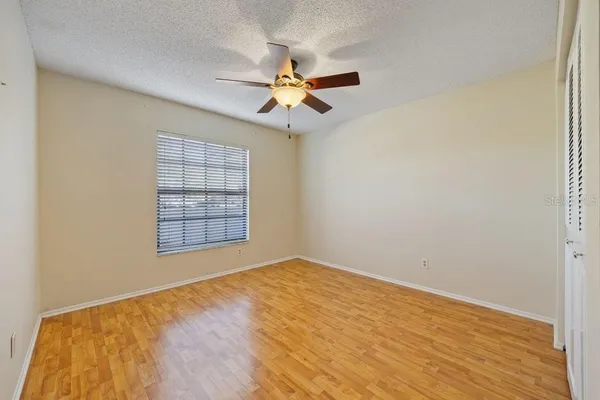 an empty room with windows and fan