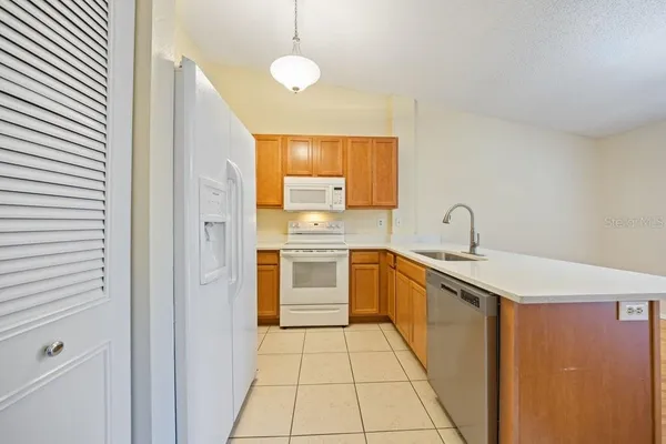 a large kitchen with a sink and dishwasher a stove top oven with wooden floor